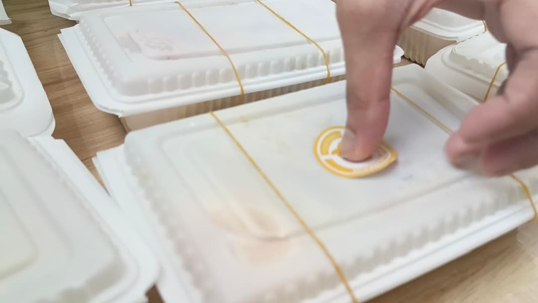 Our volunteer placing logos on the food packages • 06 December, 2025